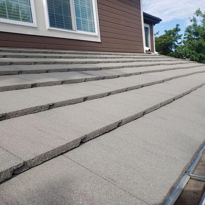 Tile roof with stepped cement tiles near gutter edge
