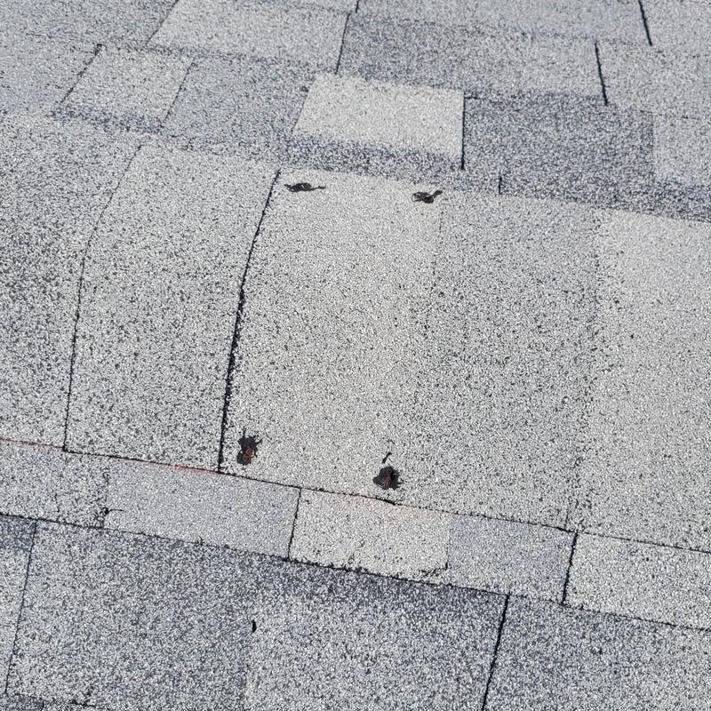 Shingle ridge vent with nail holes on roof shingles