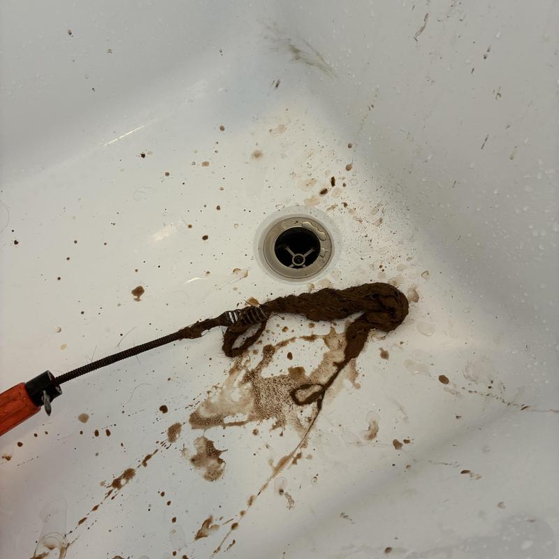Bathtub drain clog removal with hair buildup cable cleaning