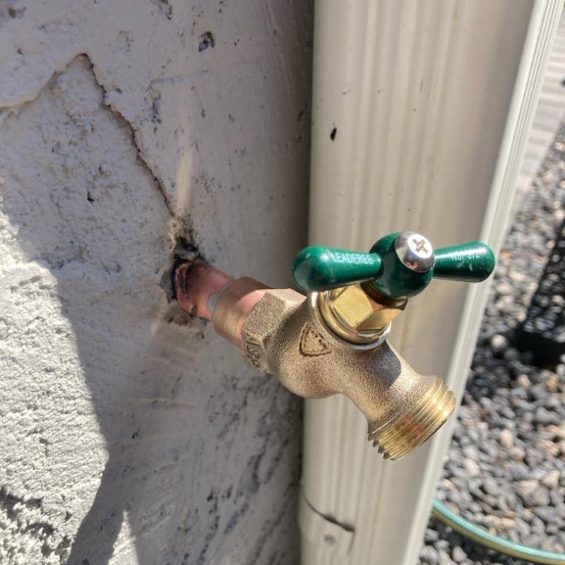 Outdoor hose bib replacement on cracked wall near gutter