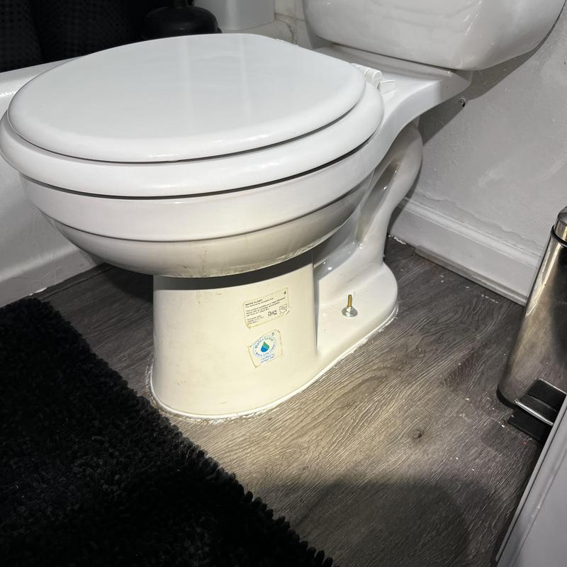 Toilet base sealed with shims on bathroom floor Toilet base sealed with shims on bathroom floor