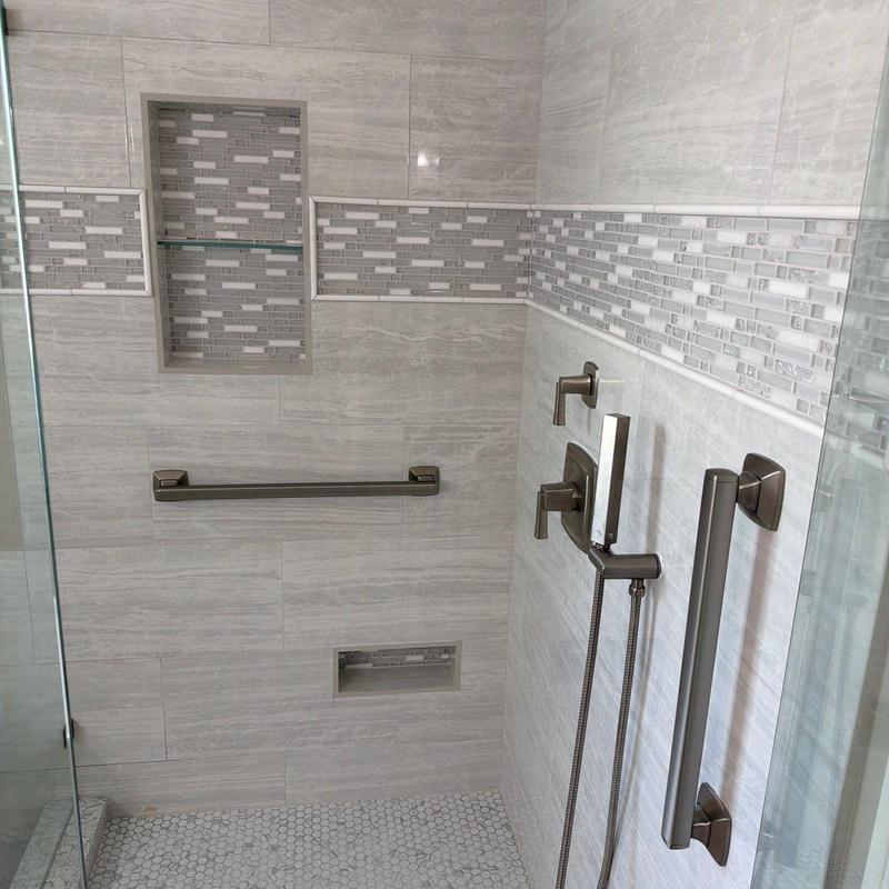 Frameless glass shower with tile niche and fixtures