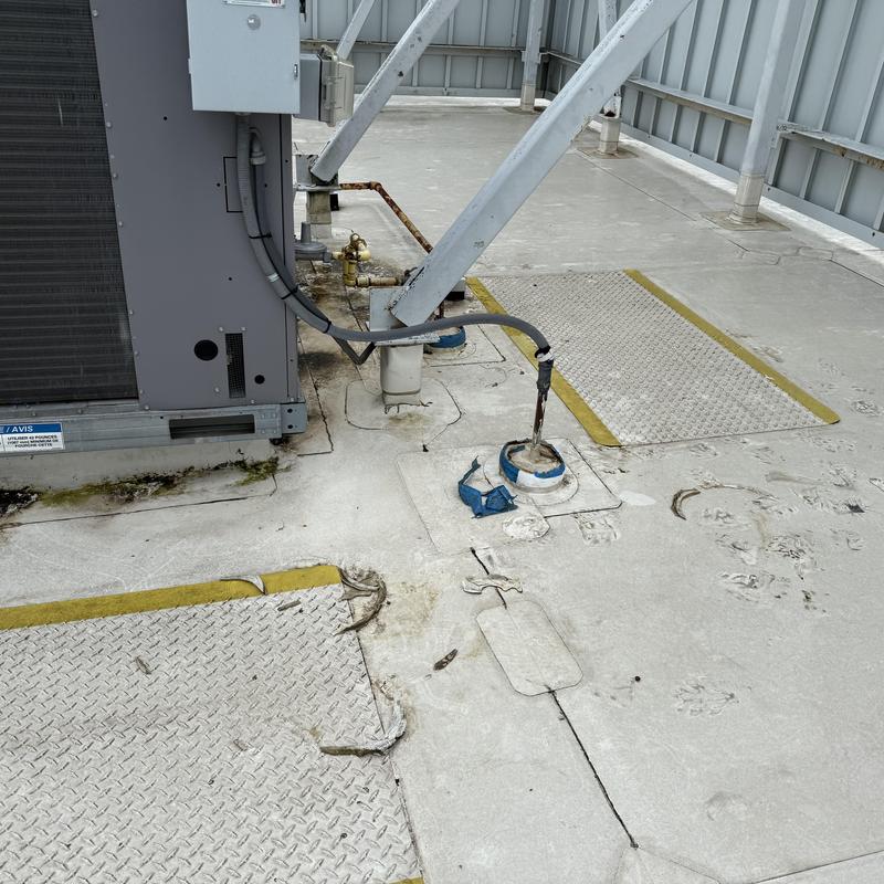 TPO roof penetration with damaged sealant and debris