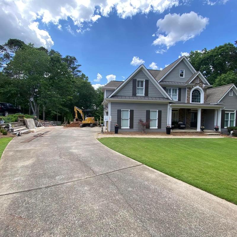 Concrete driveway with excavation equipment at house