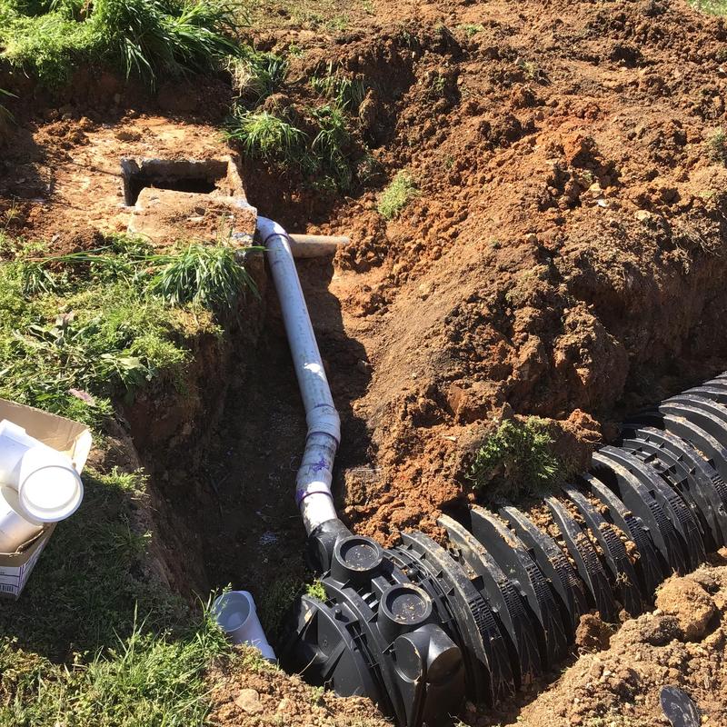 Septic tank discharge line installation in yard excavation