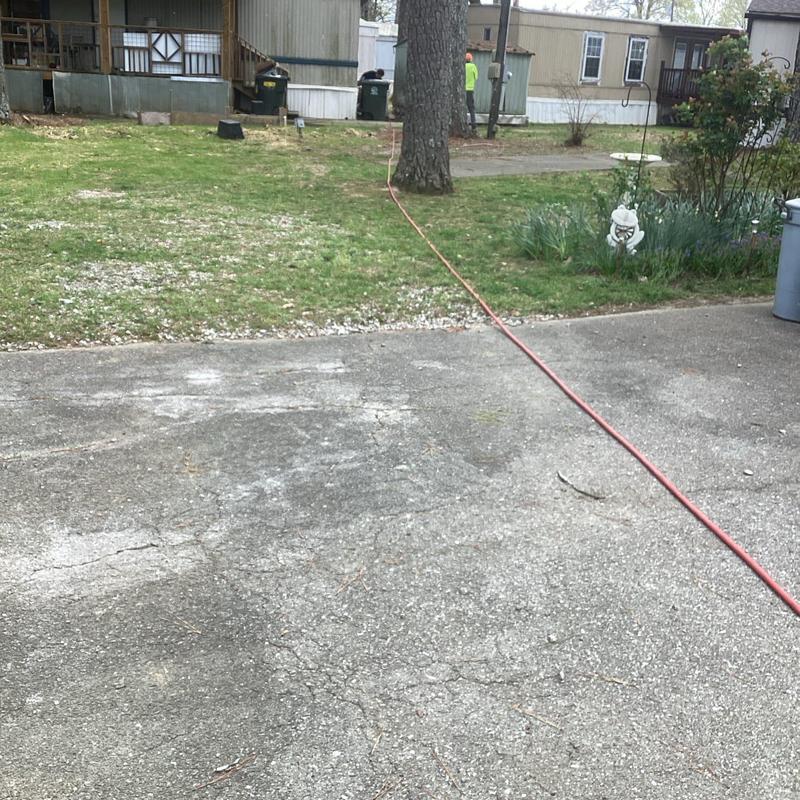 Hydro-jet drain line hose stretched across driveway