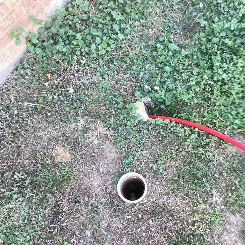 Jetted sewer line with red jetting hose outdoors