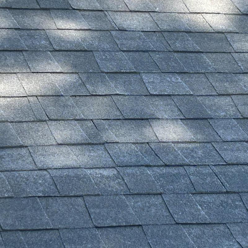 Asphalt shingle roof close-up with light shadows
