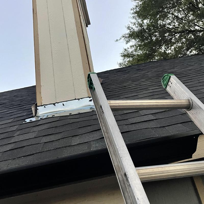 Chimney flashing installation with ladder on shingle roof