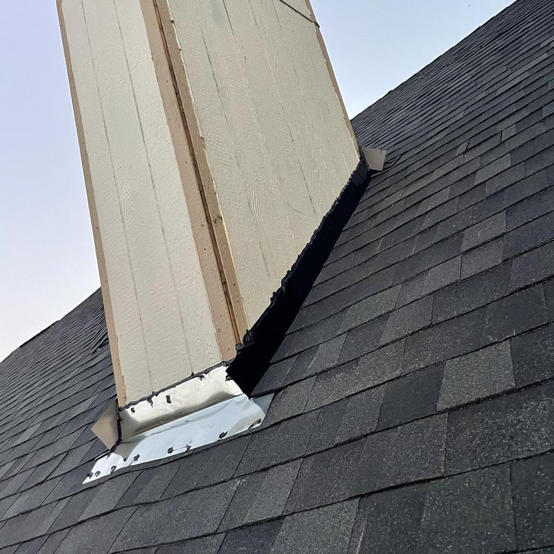 Chimney base metal flashing and new shingles installation