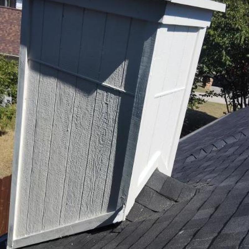Chimney base with new flashing and shingles on roof