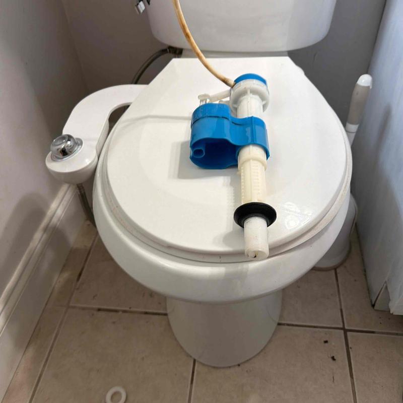 Toilet fill valve replacement parts on toilet lid