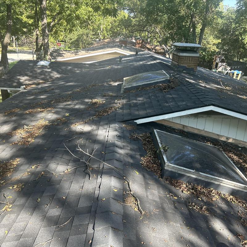 Asphalt shingle roof with leaves and debris buildup