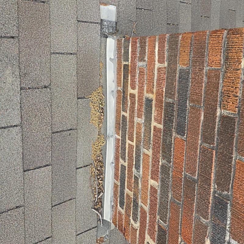 Roof shingles and chimney flashing with hail damage