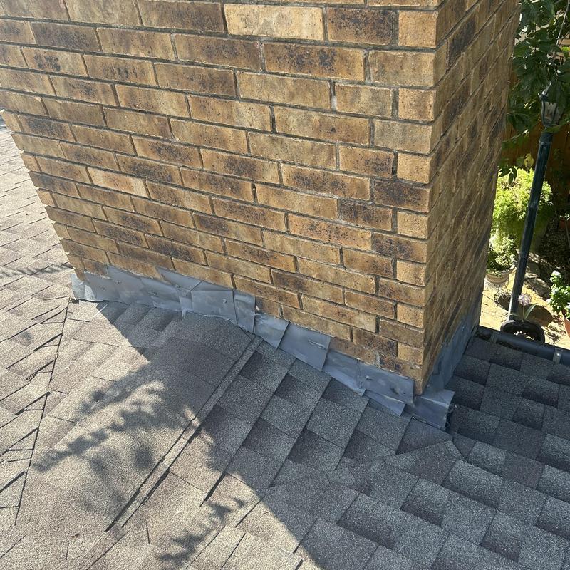Chimney flashings on asphalt shingle roof installation