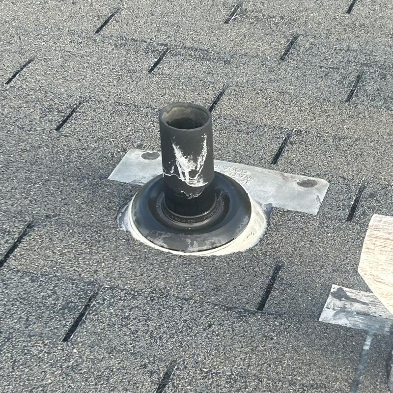 Roof vent pipe flashing with weathered sealant on shingle roof