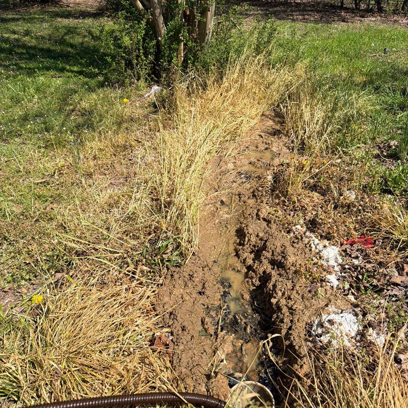 Mainline sewer cable near cleanout in muddy trench