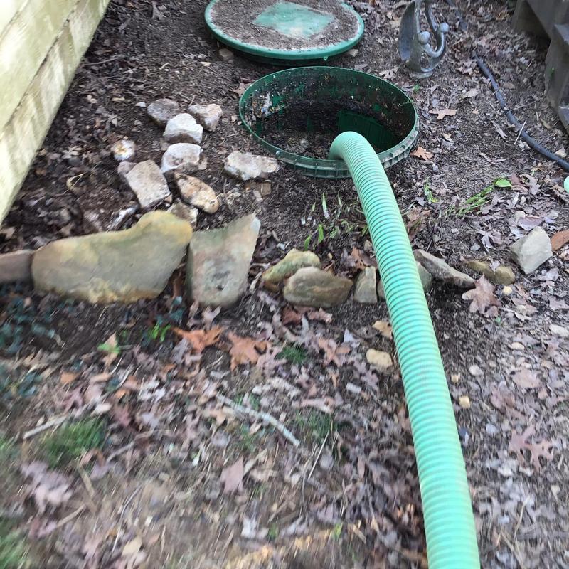 Septic tank with green suction hose in soil