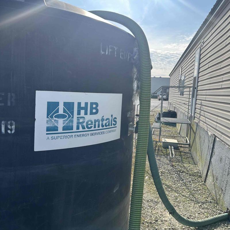 Holding tank with pump hose setup outside building