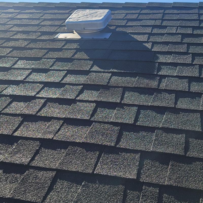 Asphalt roof shingles with hail damage near vent