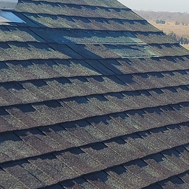 Asphalt shingle roof with hail damage close-up