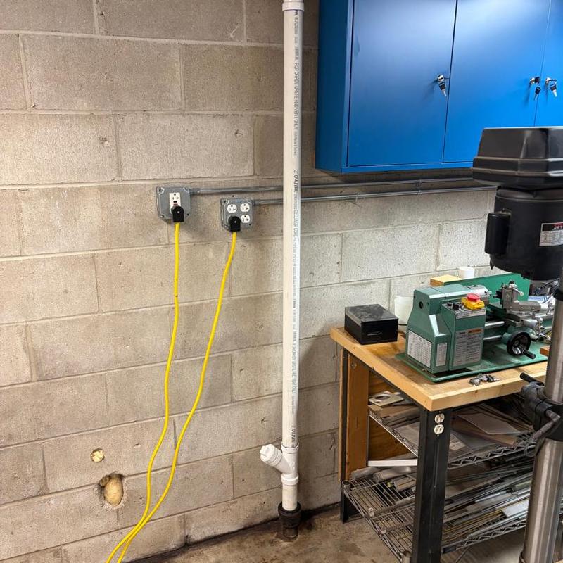 PVC drainage pipe installation in workshop corner