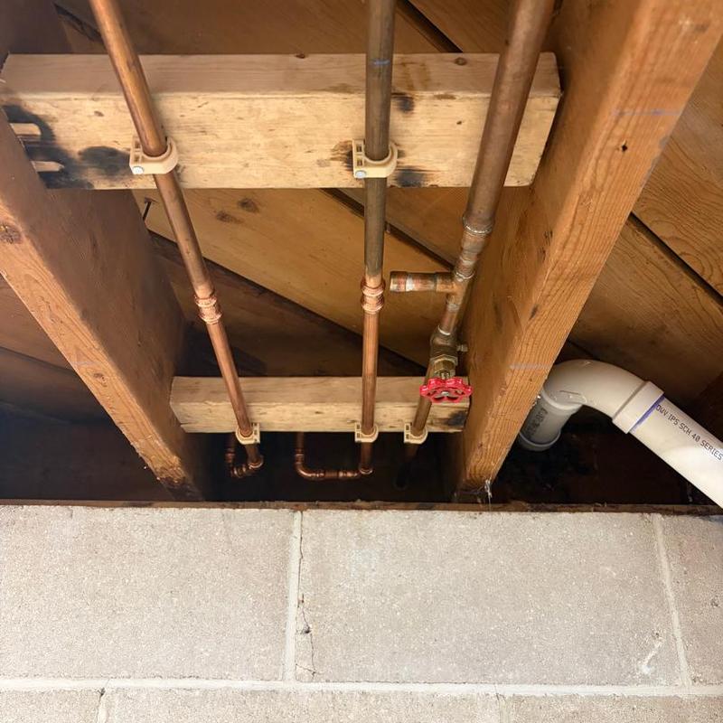 Copper water supply pipes with shutoff valve in basement ceiling