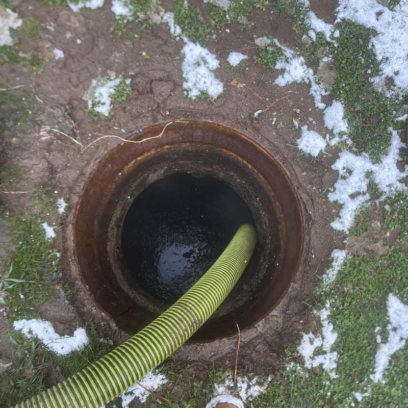 Septic tank with hose pumping out contents outdoors