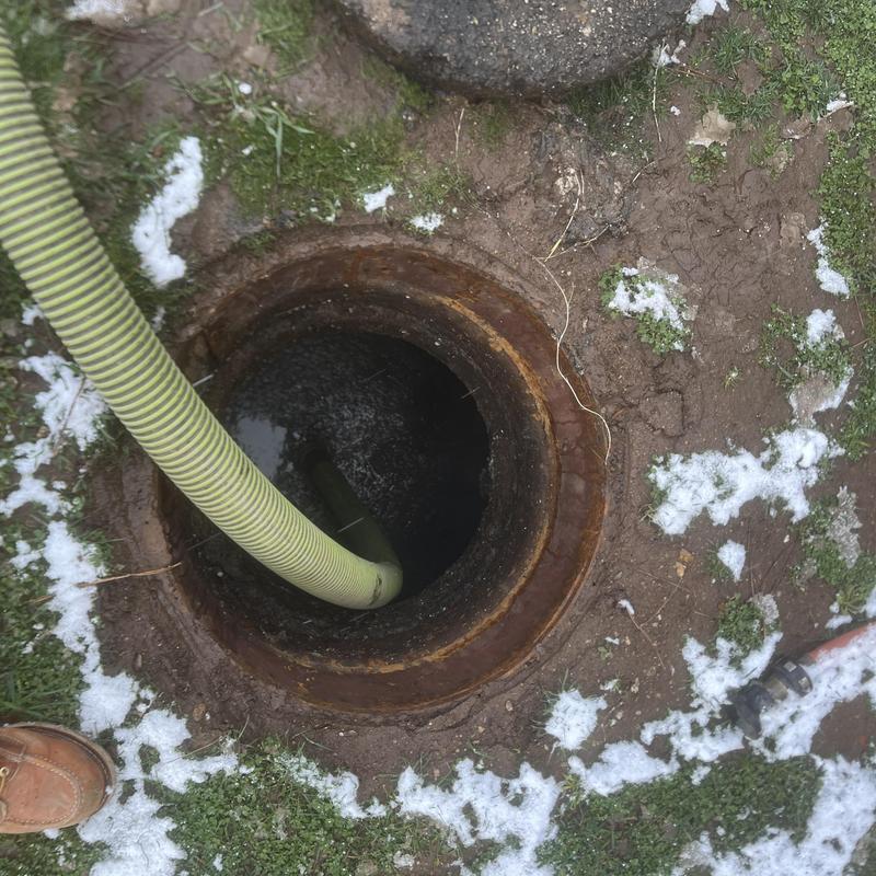 Septic tank pump out with inspection hose inserted