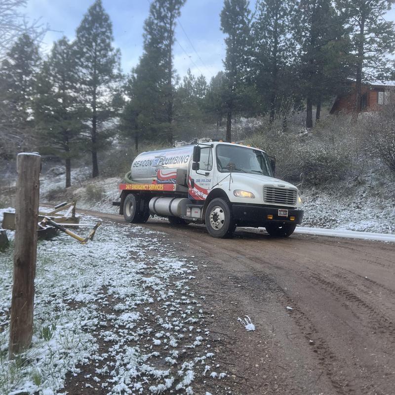 Septic tank pump-out truck on rural snowy road