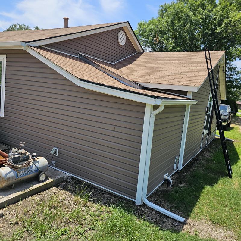 Asphalt shingle roof with hail damage and ladder nearby