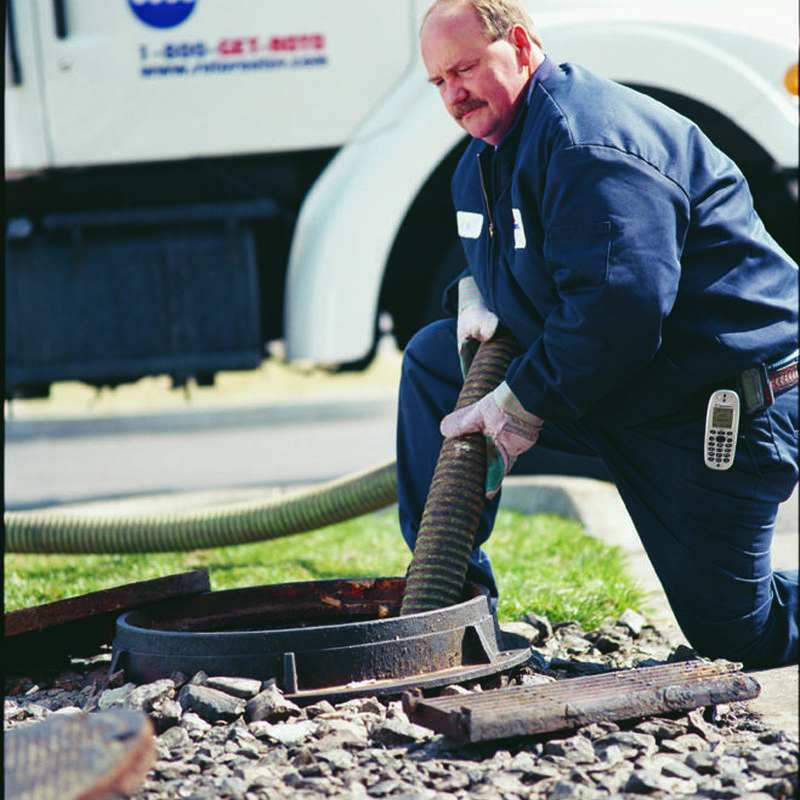 Septic tank pumping with hose and technician