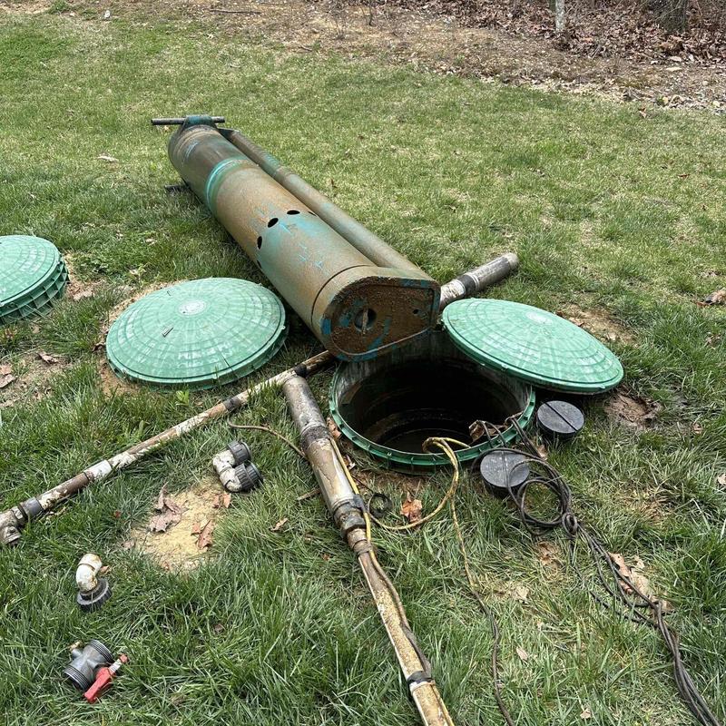 Sump pump system with removed cover and pump laid out