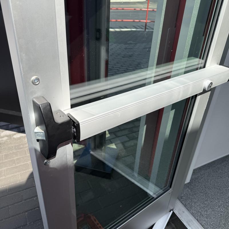 Exit device on aluminum commercial door with glass panel