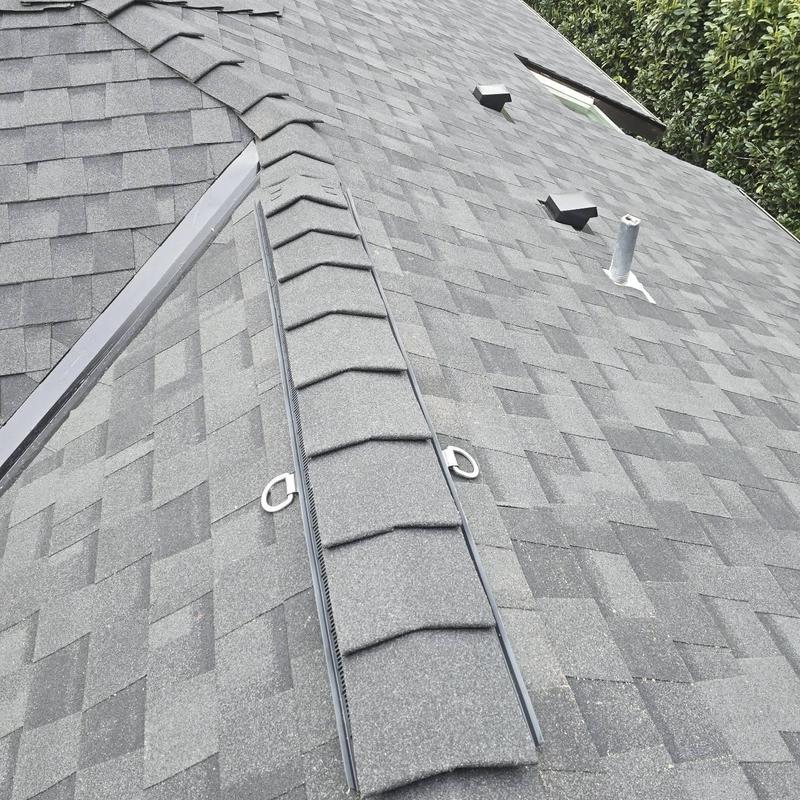 Asphalt shingle roof with ridge vent and flashing