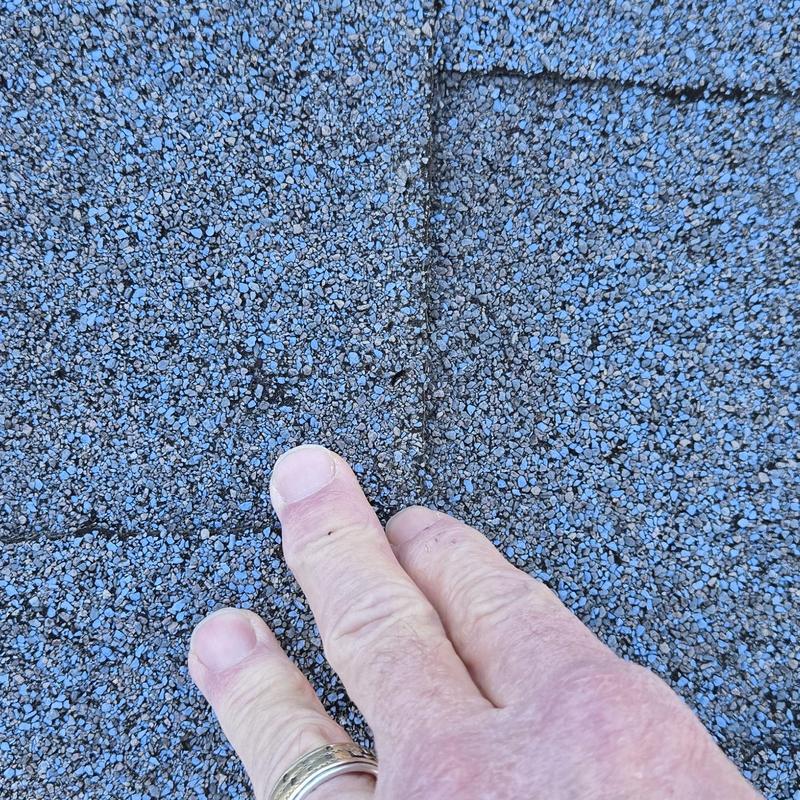 Asphalt shingle roofing granule loss from hail damage close-up