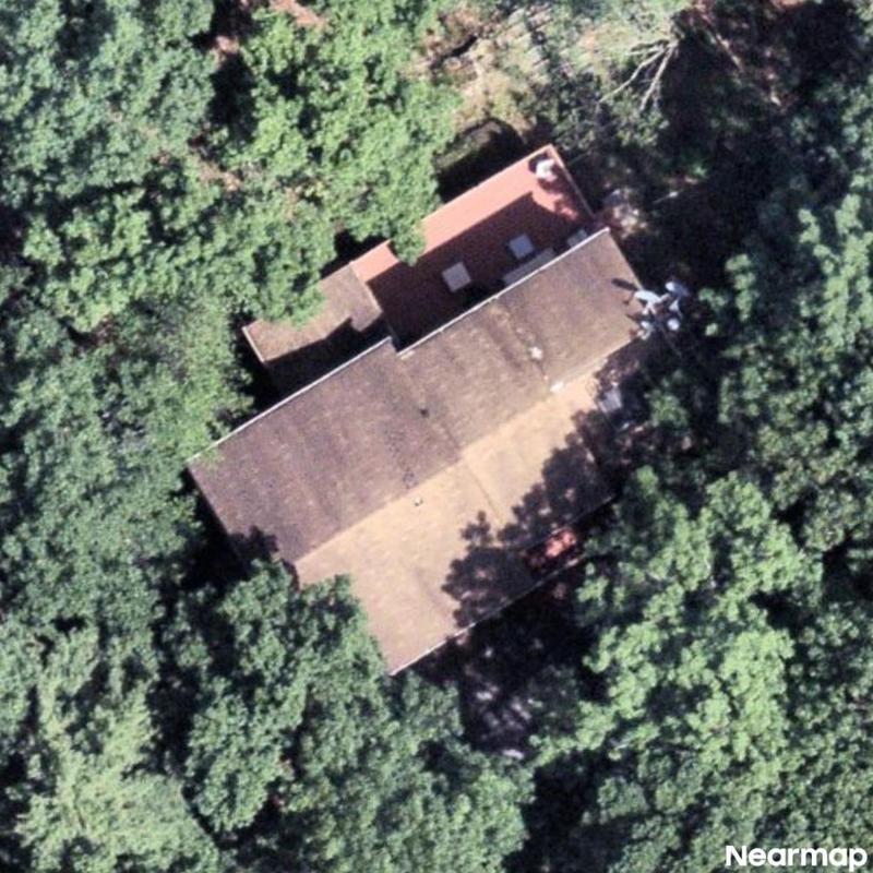 Roof surface aerial view surrounded by dense trees