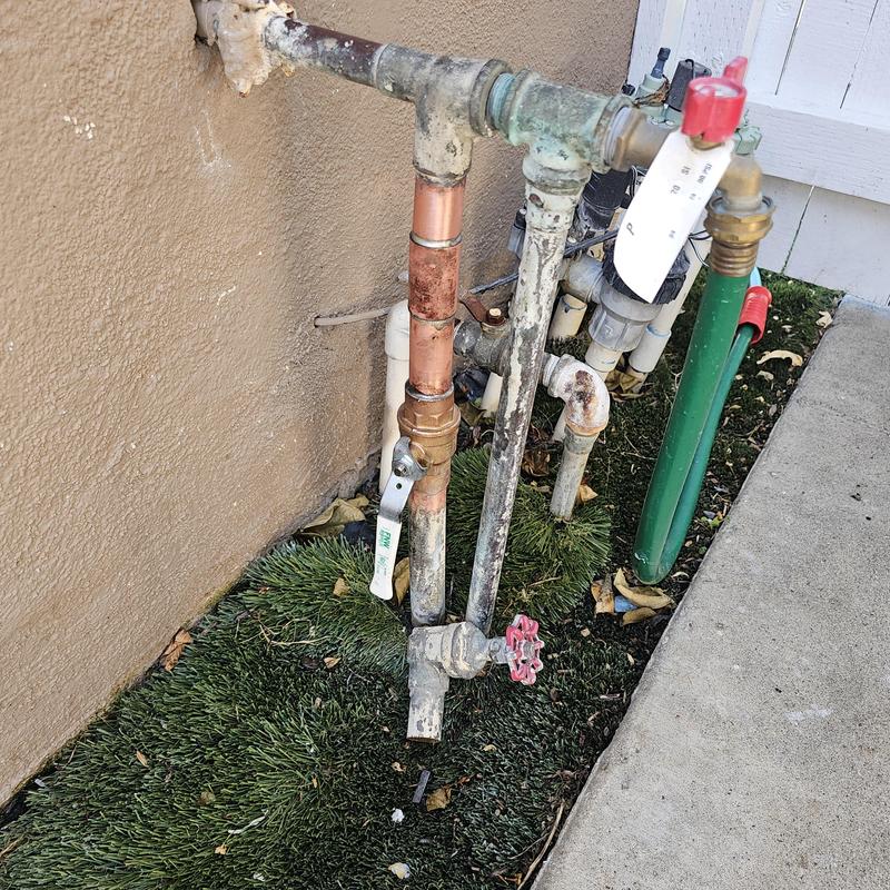 Copper piping and outdoor valve near building wall