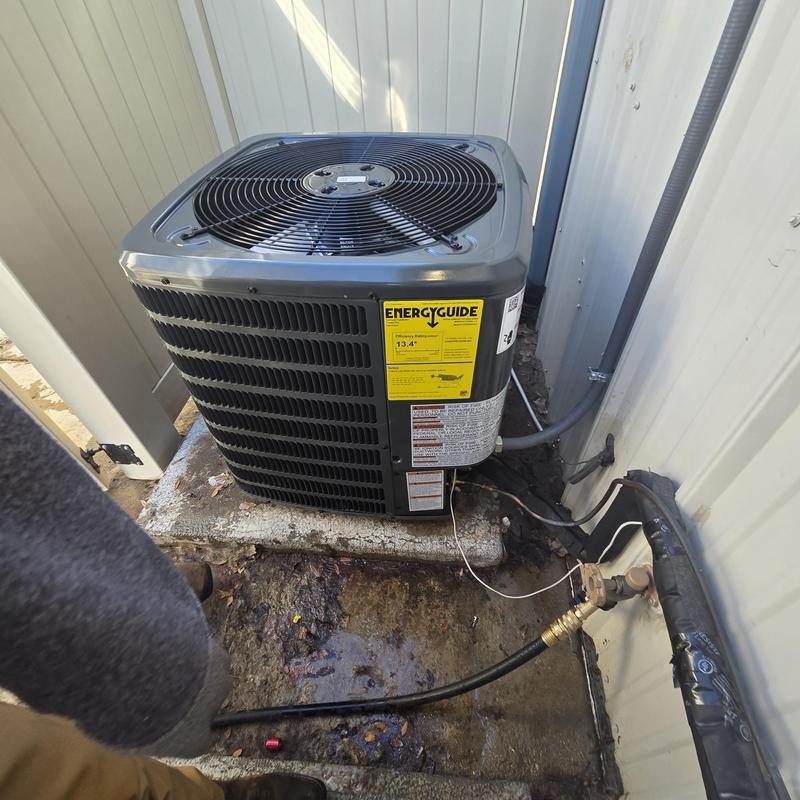 Outdoor air conditioning condenser unit by building wall