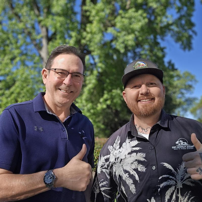 Kitchen faucet installation with two smiling men thumbs up