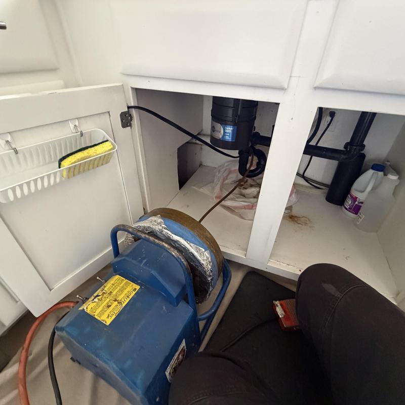 Kitchen sink drain with cleaning machine under cabinet