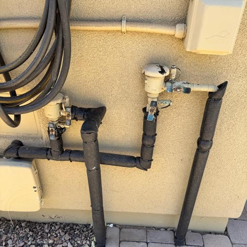 Pressure vacuum breakers with insulated pipes on wall