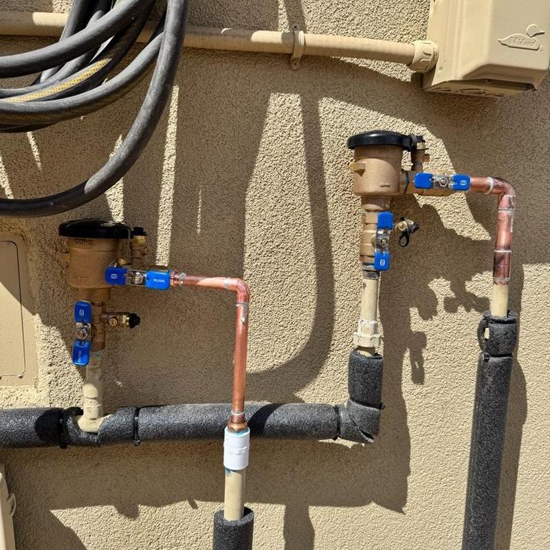 Pressure vacuum breakers and copper piping on wall