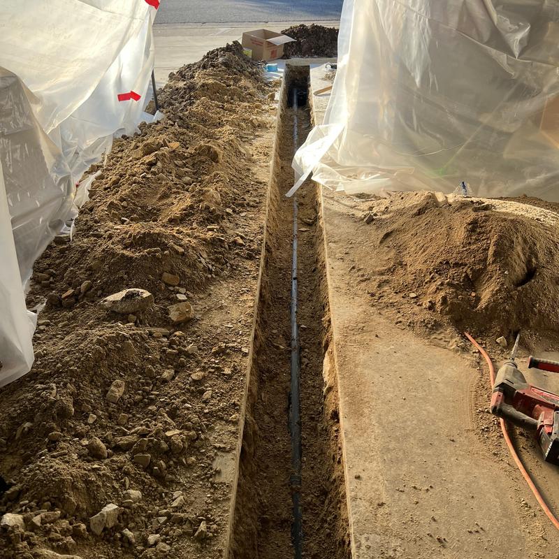 Drain pipe trench cutting and pipe installation in yard