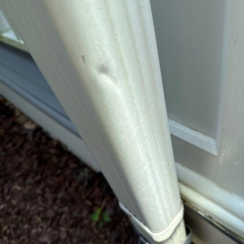 Downspout dent on exterior gutter system section