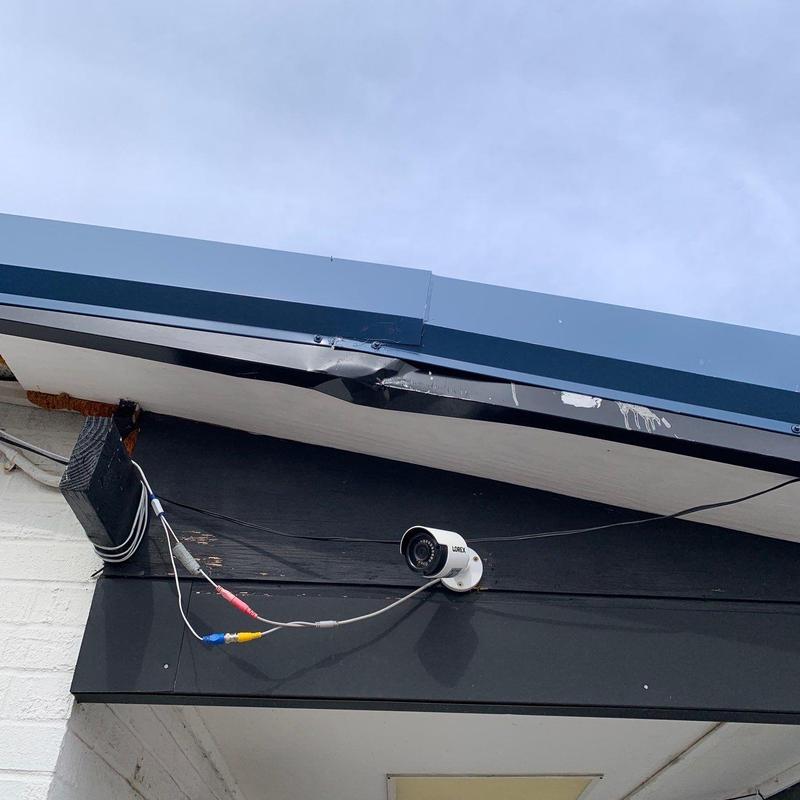 Metal roof edge with dent near security camera