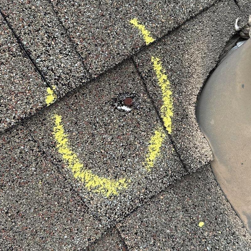 Roof shingles with hail damage marked in yellow chalk