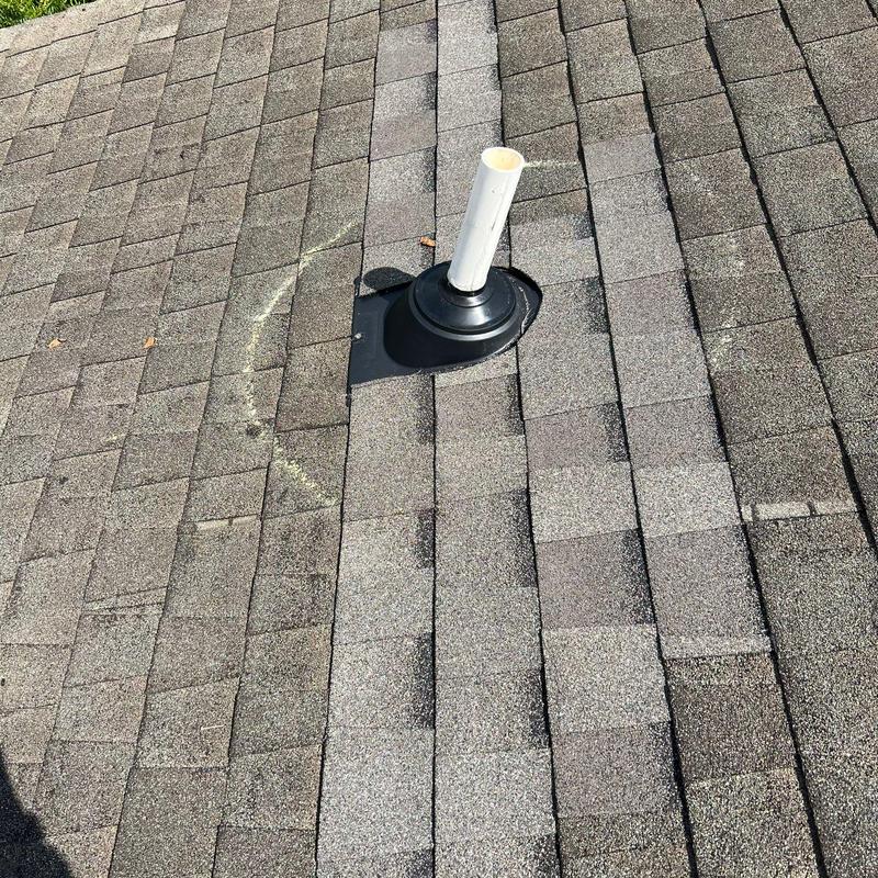 Roof shingles with hail damage around pipe boot flashing