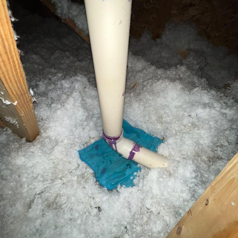 PVC drain pipe with insulation and pipe support in attic