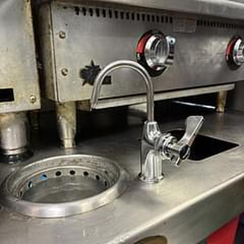 Commercial sink faucet installation on stainless steel counter